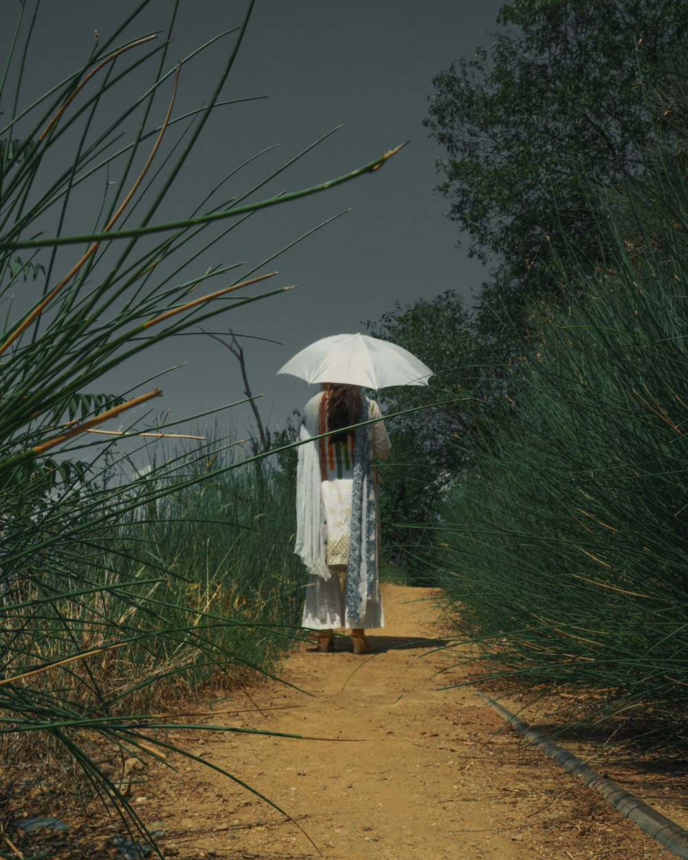 woman in white dress standing on green grass field during daytime