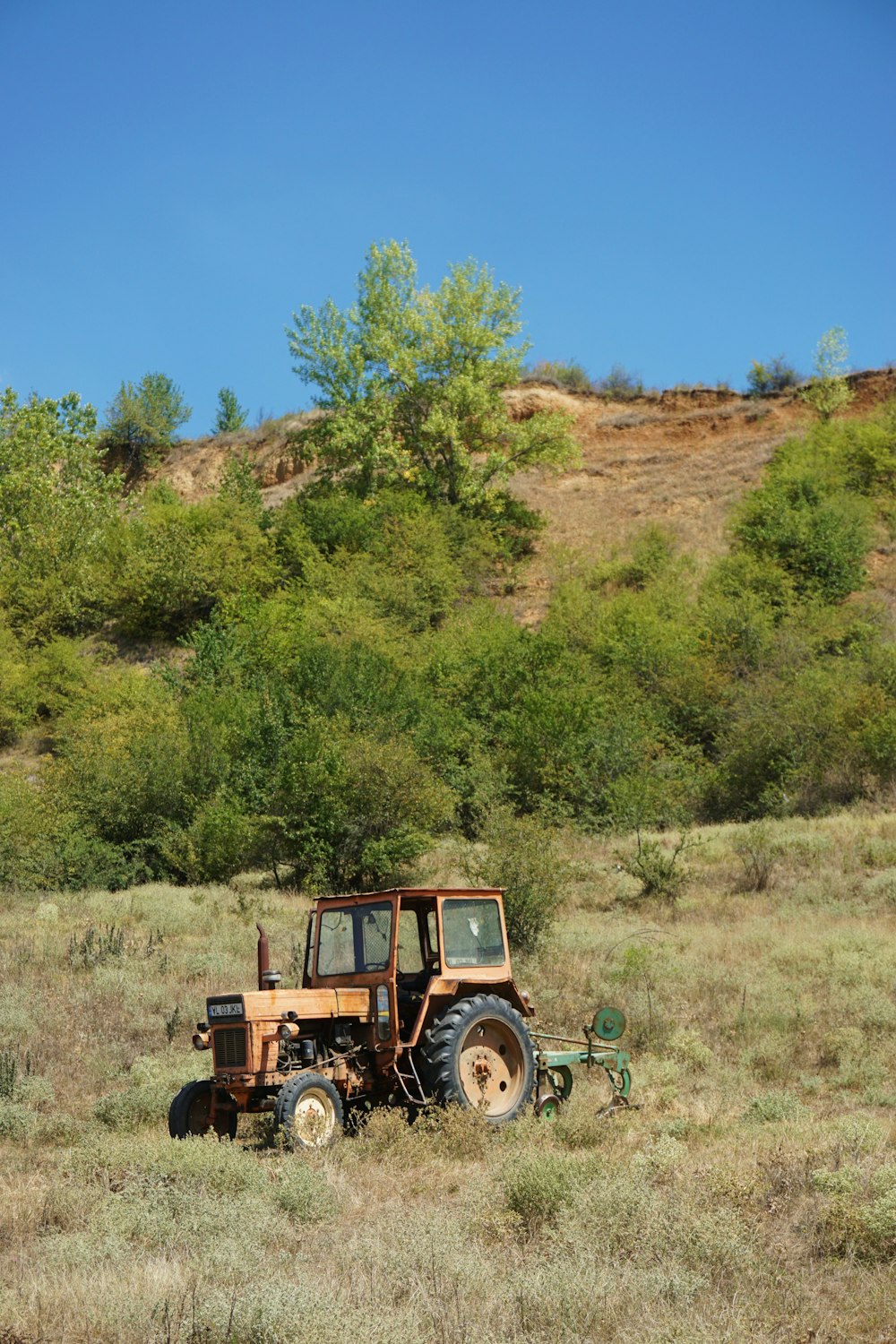 brown tractor on green grass field during daytime