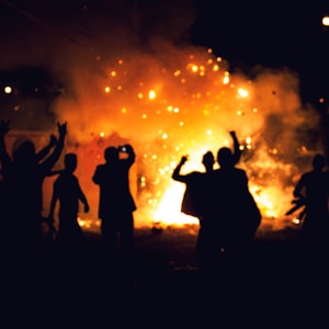 silhouette of people standing on field with fireworks