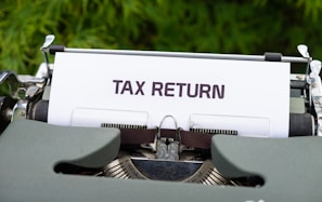 a close up of a typewriter with a tax return sign on it