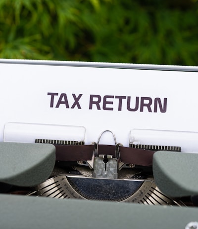 a close up of a typewriter with a tax return sign on it