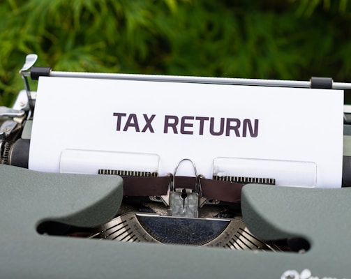 a close up of a typewriter with a tax return sign on it