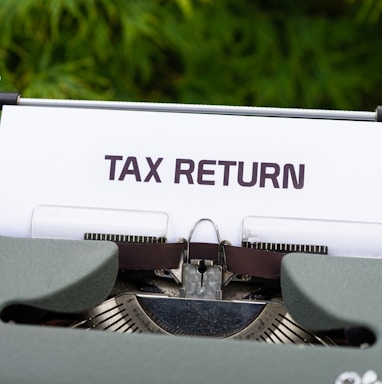 a close up of a typewriter with a tax return sign on it