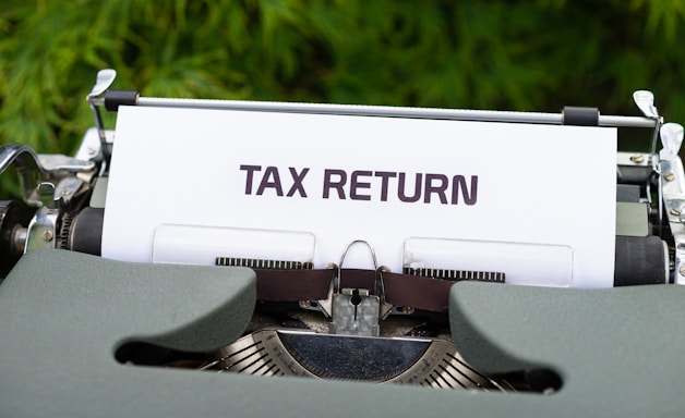 a close up of a typewriter with a tax return sign on it