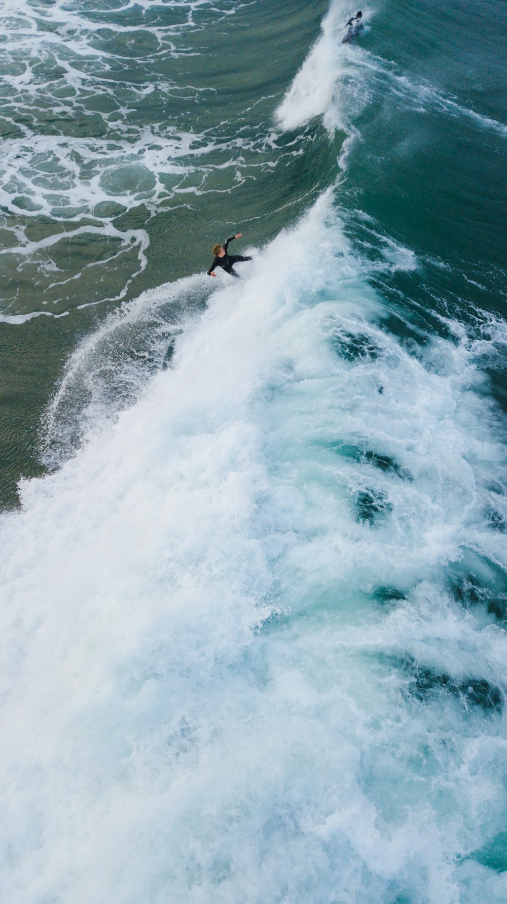 person surfing on sea waves during daytime