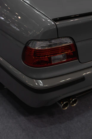 Side view of a car with a newly fitted custom exhaust system glowing under soft garage lighting.