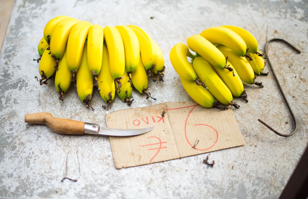 yellow banana fruit on brown wooden chopping board