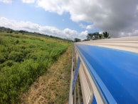 A train traveling through picturesque landscapes under a clear blue sky.