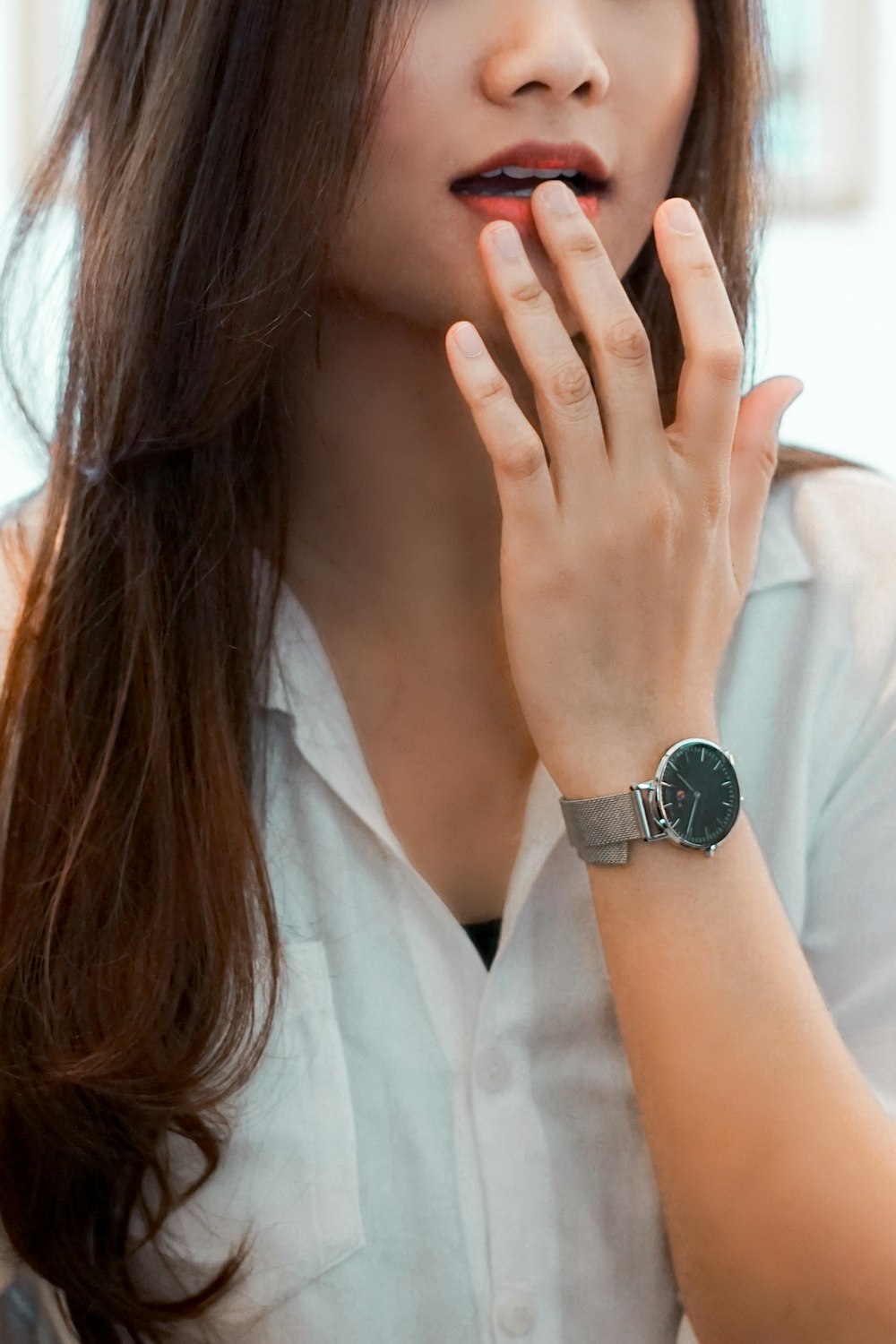 woman in white button up shirt wearing silver round analog watch
