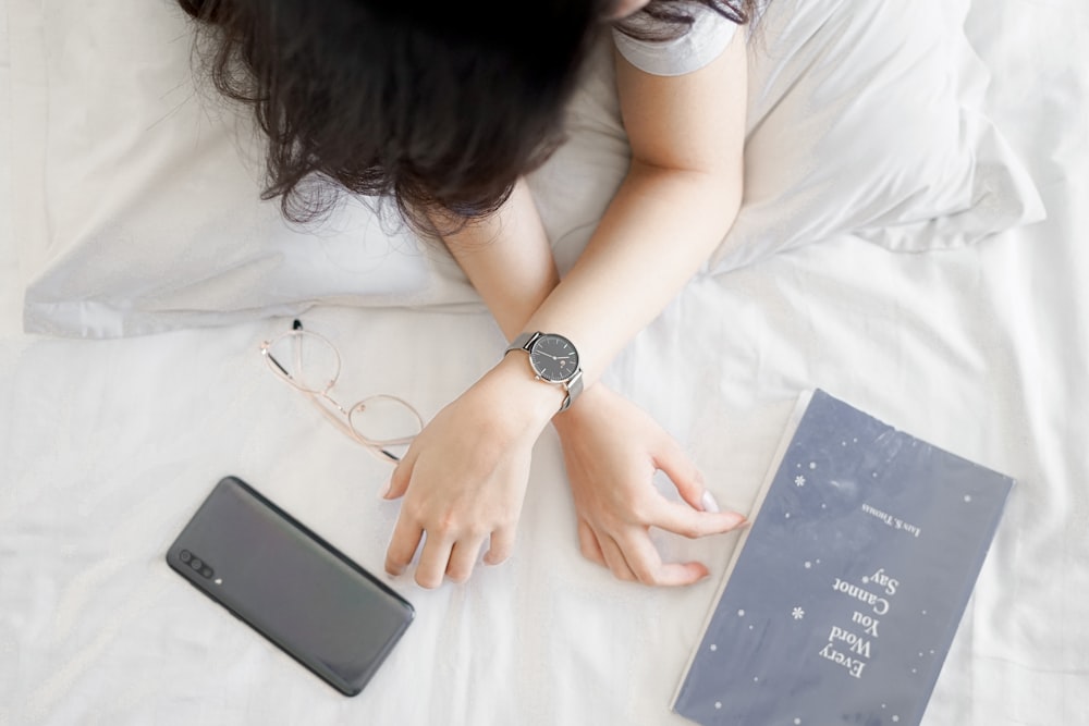 Mujer con camisa blanca con pulsera de eslabones plateados reloj analógico redondo