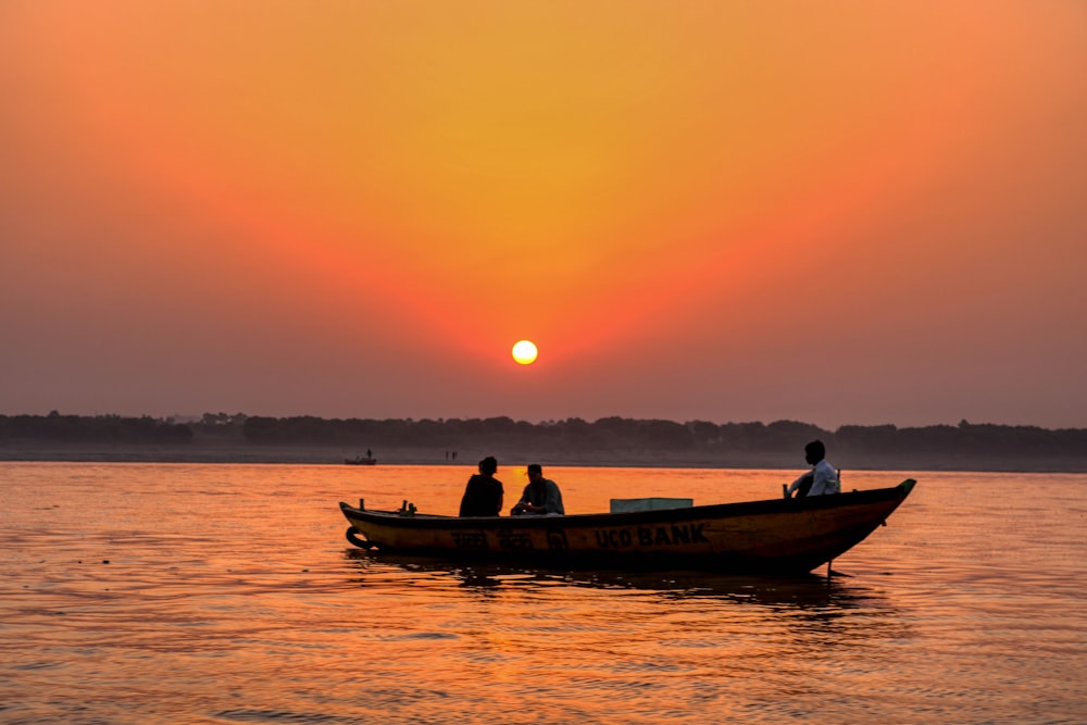 silhueta de 2 pessoas andando no barco durante o pôr do sol