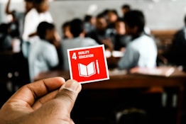 Edu.Psyched discussion page on their mission to align with the UN sustainability goals. This picture is of a hand holding a peice of paper with number four of the global goals listed which is quality education. Our primary goal is to deliver quality education to become a global partnership in improving the world through execution of the sustainaibility goals