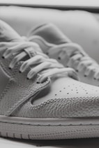 A close-up of a hand showcasing a sneaker, highlighting its detailed craftsmanship.