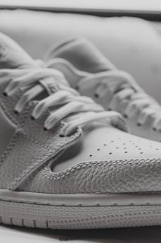 A close-up of a hand showcasing a sneaker, highlighting its detailed craftsmanship.
