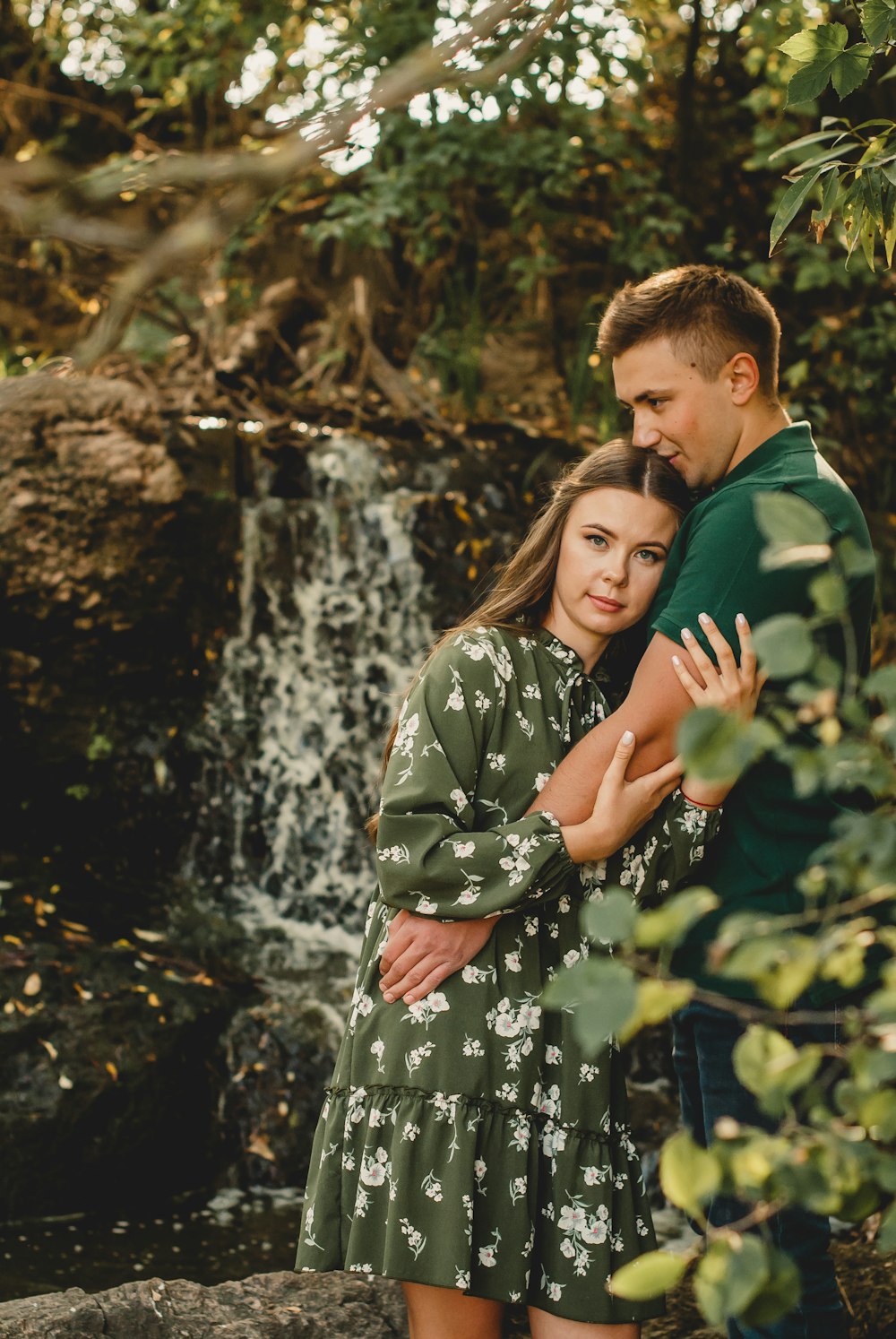 man and woman standing beside river during daytime