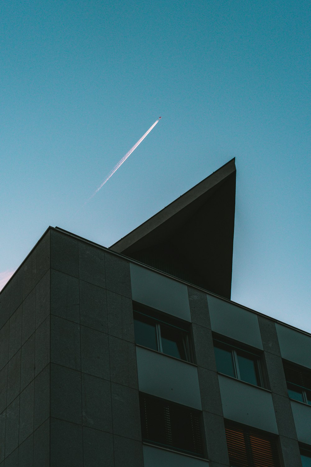 edificio in cemento nero sotto il cielo blu durante il giorno