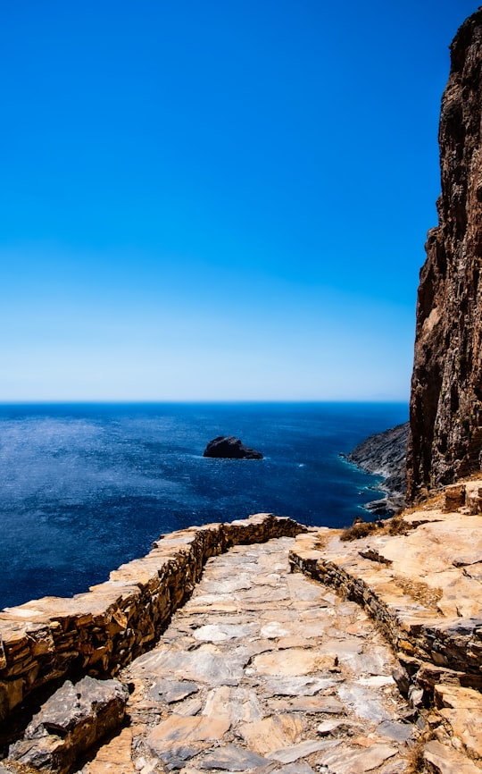 brown rocky mountain beside blue sea under blue sky during daytime in Amorgos Greece