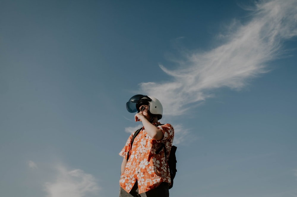 woman in blue and red floral dress wearing white hat under blue sky during daytime