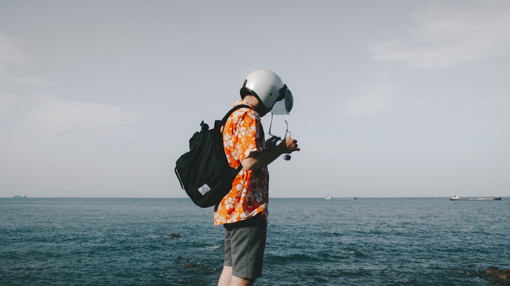 Homme en veste noire et casque blanc tenant un textile orange et blanc