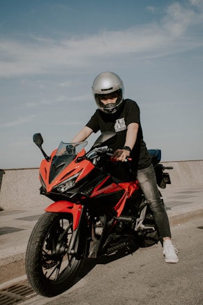 man in black and red motorcycle helmet riding on red and black sports bike