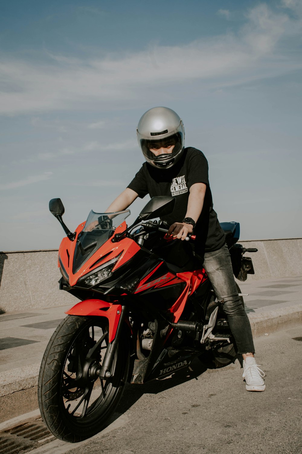 man in black and red motorcycle helmet riding on red and black sports bike