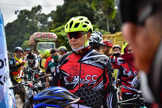 man in red and white racing suit riding on motorcycle during daytime in Jambi Indonesia