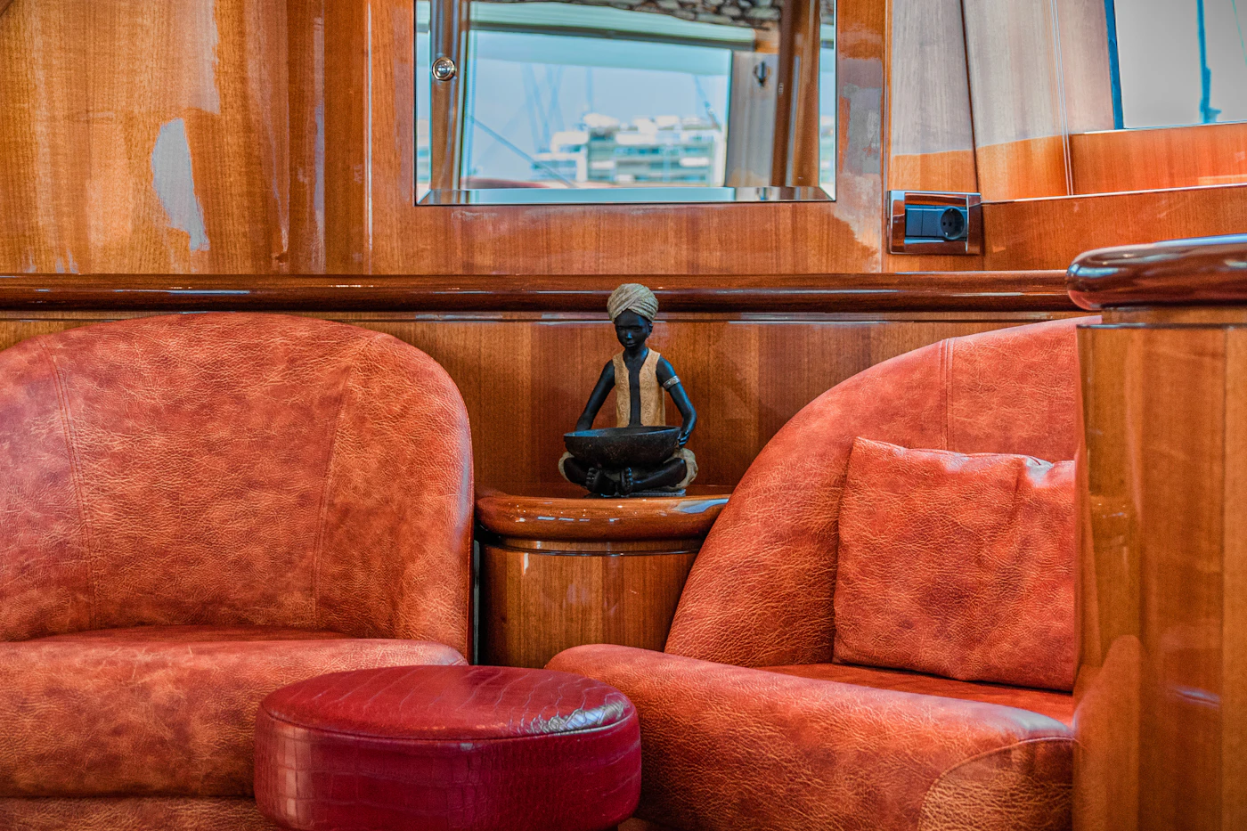 Lounge with coral armchairs and varnished wood panelling