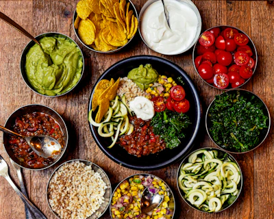 A fresh bowl of colorful, healthy food ingredients arranged neatly on a wooden table.