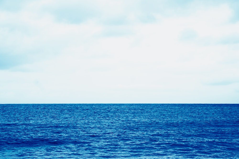 body of water under cloudy sky during daytime