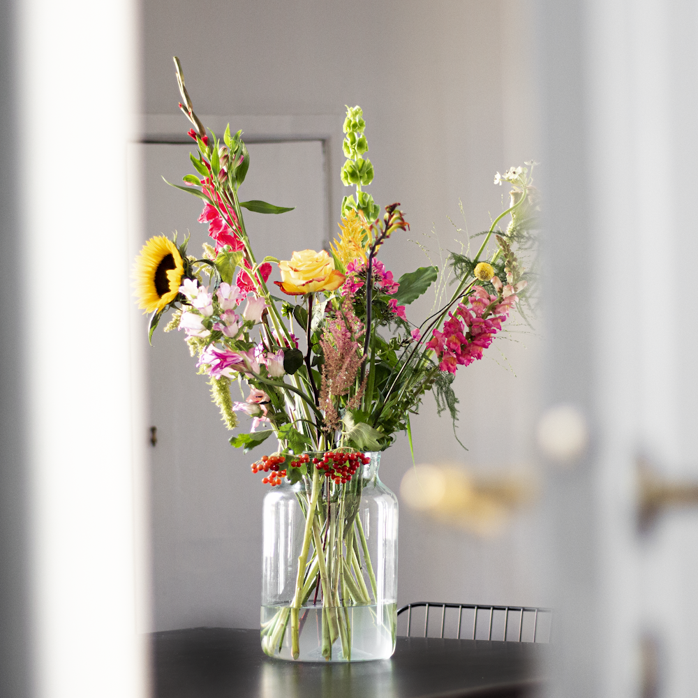 yellow and red flowers in clear glass vase