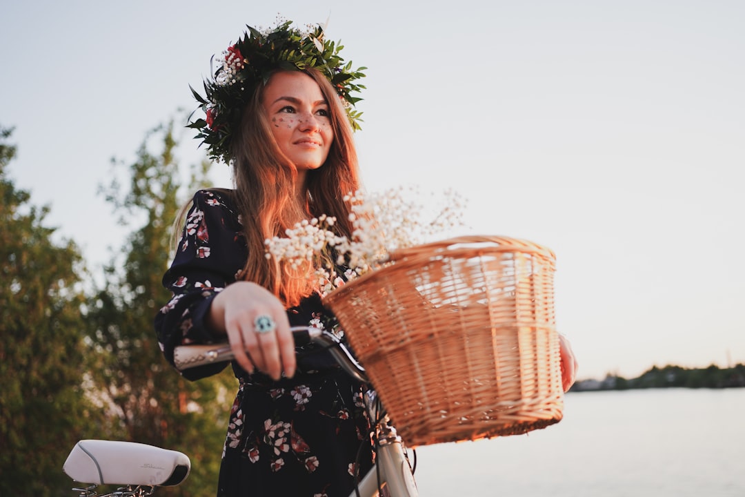 woman in black and white floral long sleeve dress holding brown woven basket