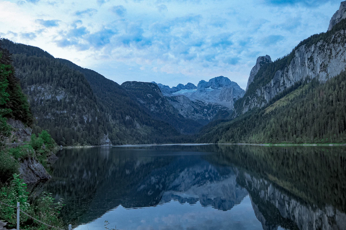 The Gosausee at dusk, reflecting forested slopes and rocky peaks