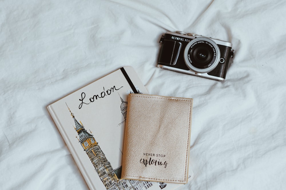 black and silver camera beside brown leather case