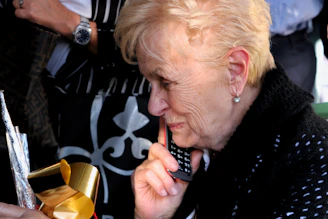 An elderly person holding a phone looking cautious while receiving a suspicious call.
