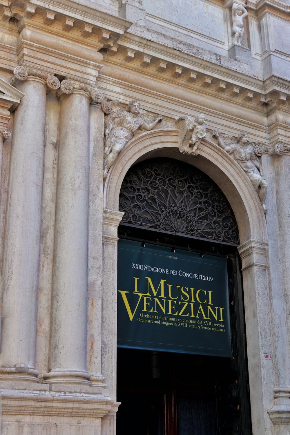 the entrance to a building with columns and a sign