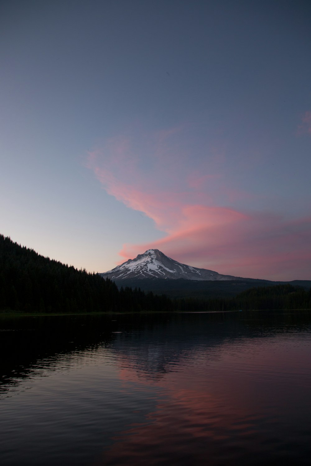 body of water near mountain under blue sky during daytime