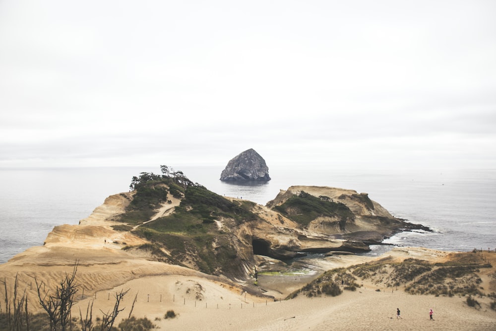 a group of people standing on top of a sandy beach