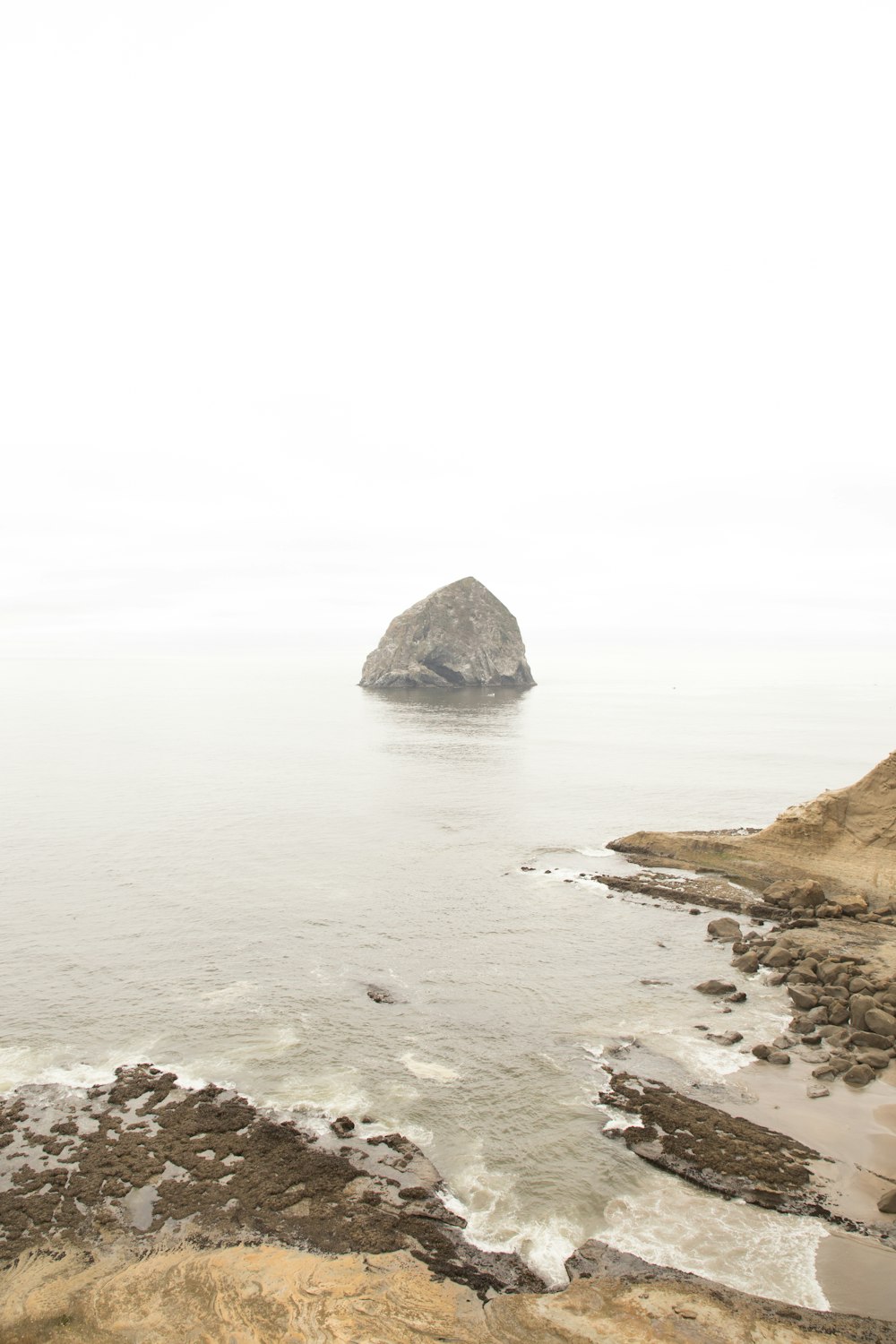 a large rock in the middle of a body of water