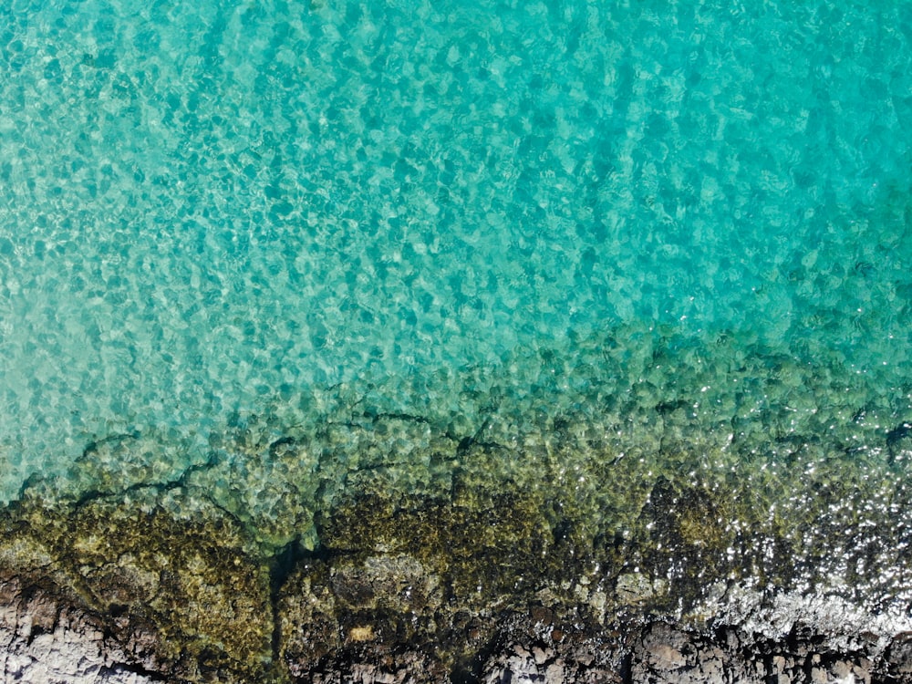 body of water near brown rocks