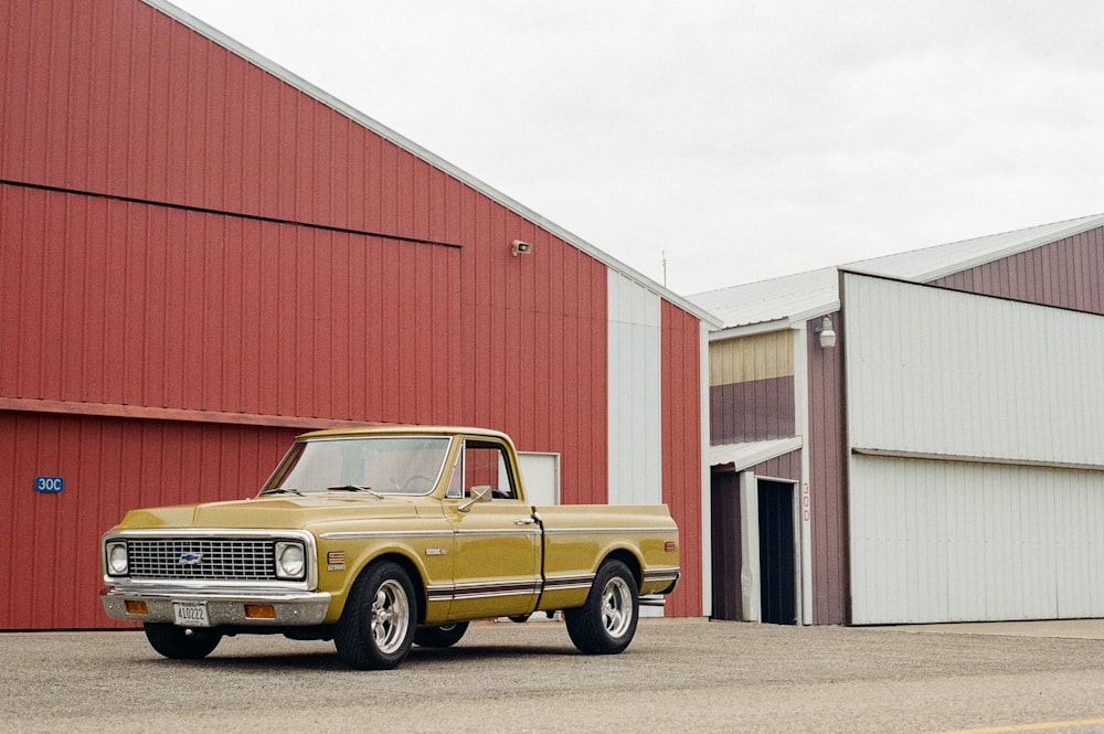 a yellow truck parked in front of a red building