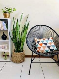 black metal framed white and blue striped padded chair beside green indoor plant