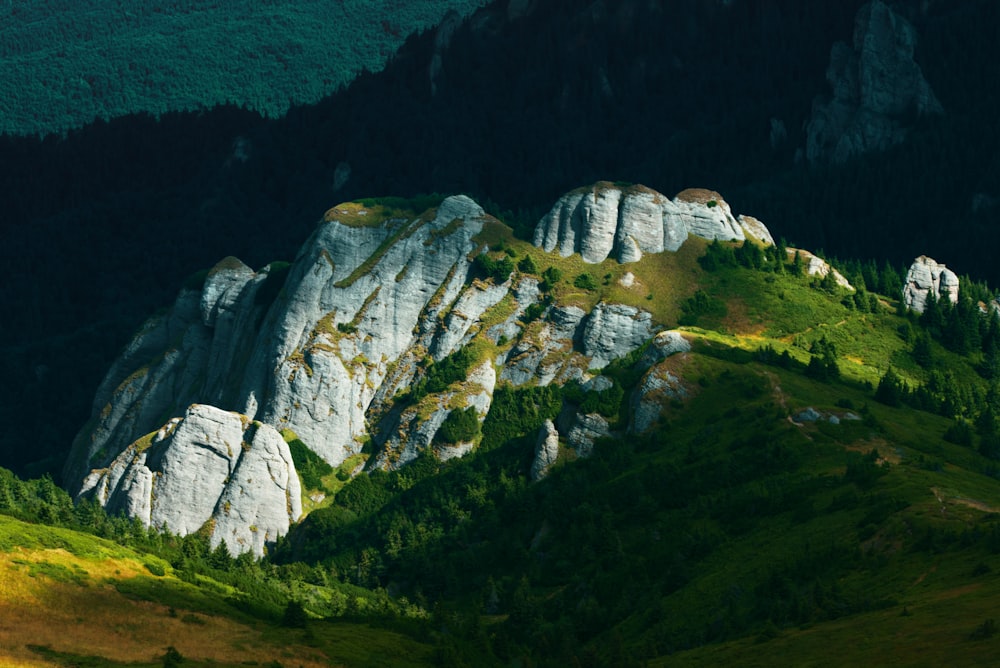 montanha rochosa verde e cinzenta durante o dia
