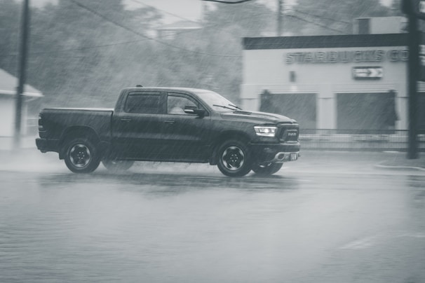 A truck driving through a city street during the day.