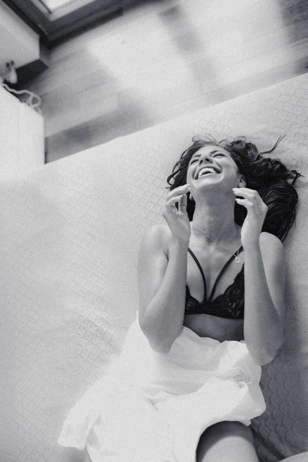 woman in white tank top lying on bed