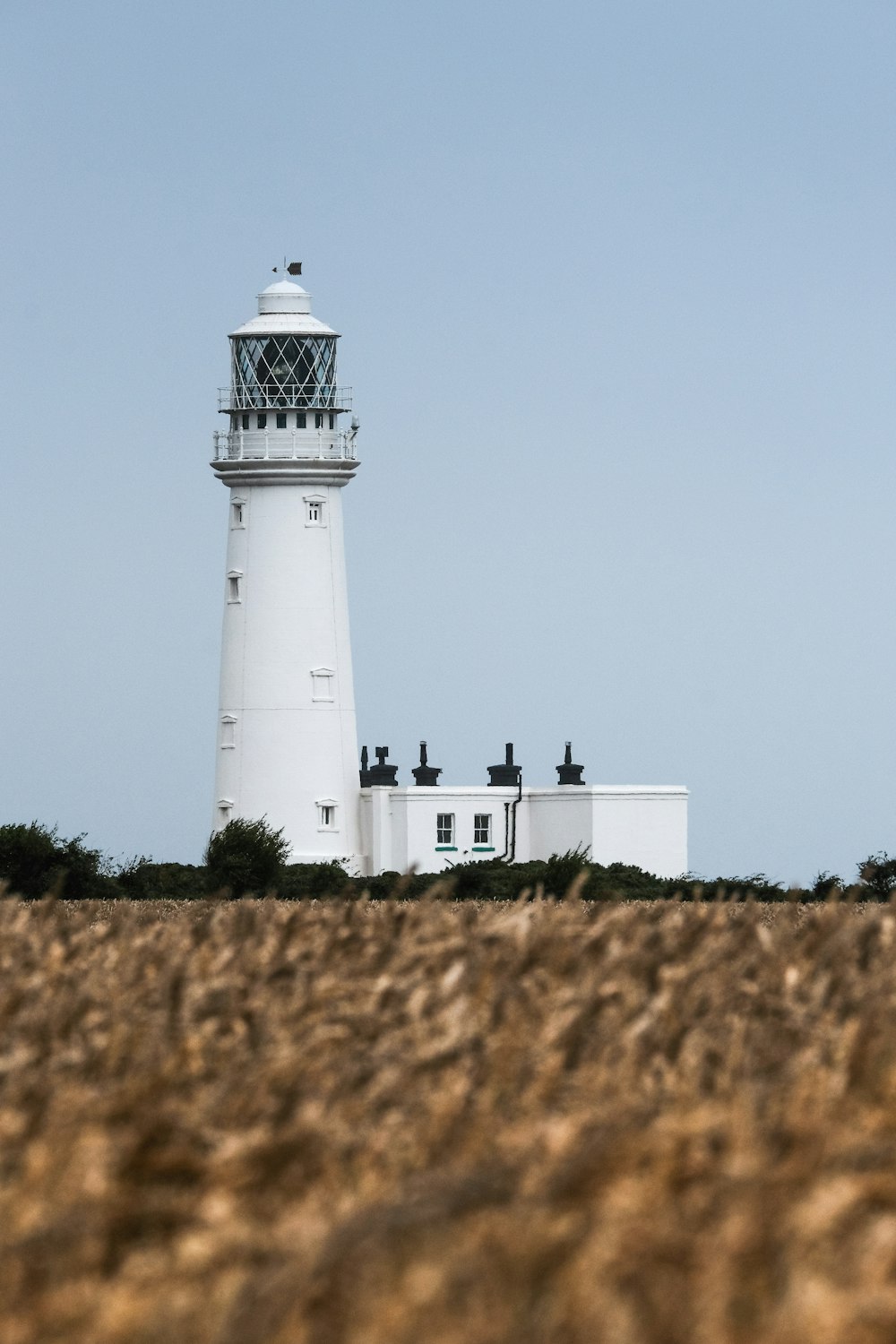 white and black lighthouse under gray sky