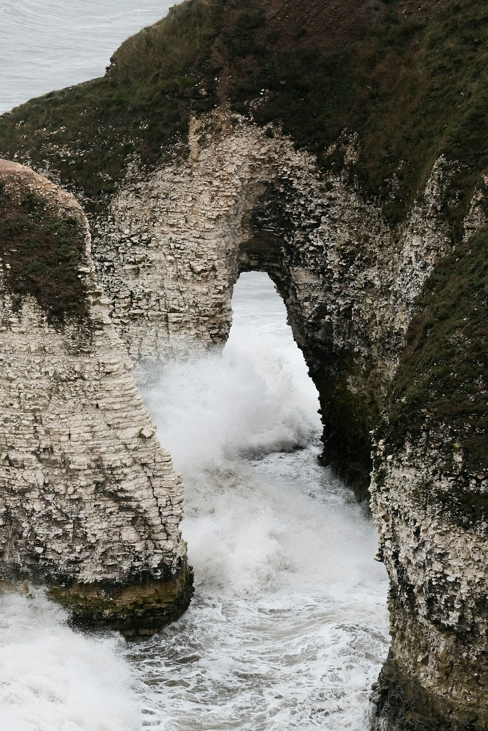 water falls between rocky mountain during daytime