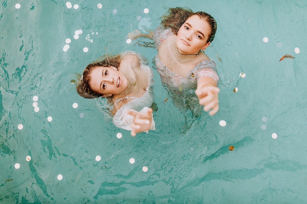 2 girls in water during daytime