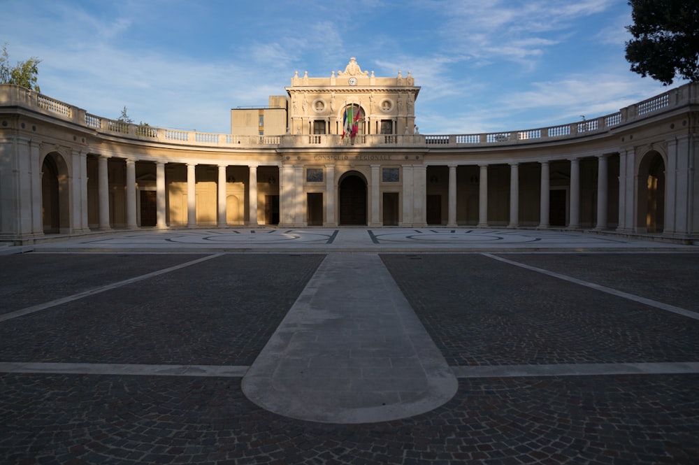 Bâtiment en béton beige sous ciel bleu pendant la journée