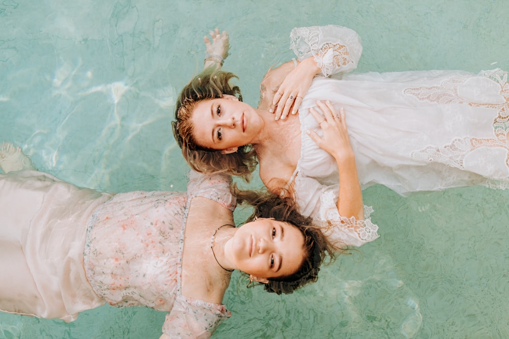 2 girls lying on water