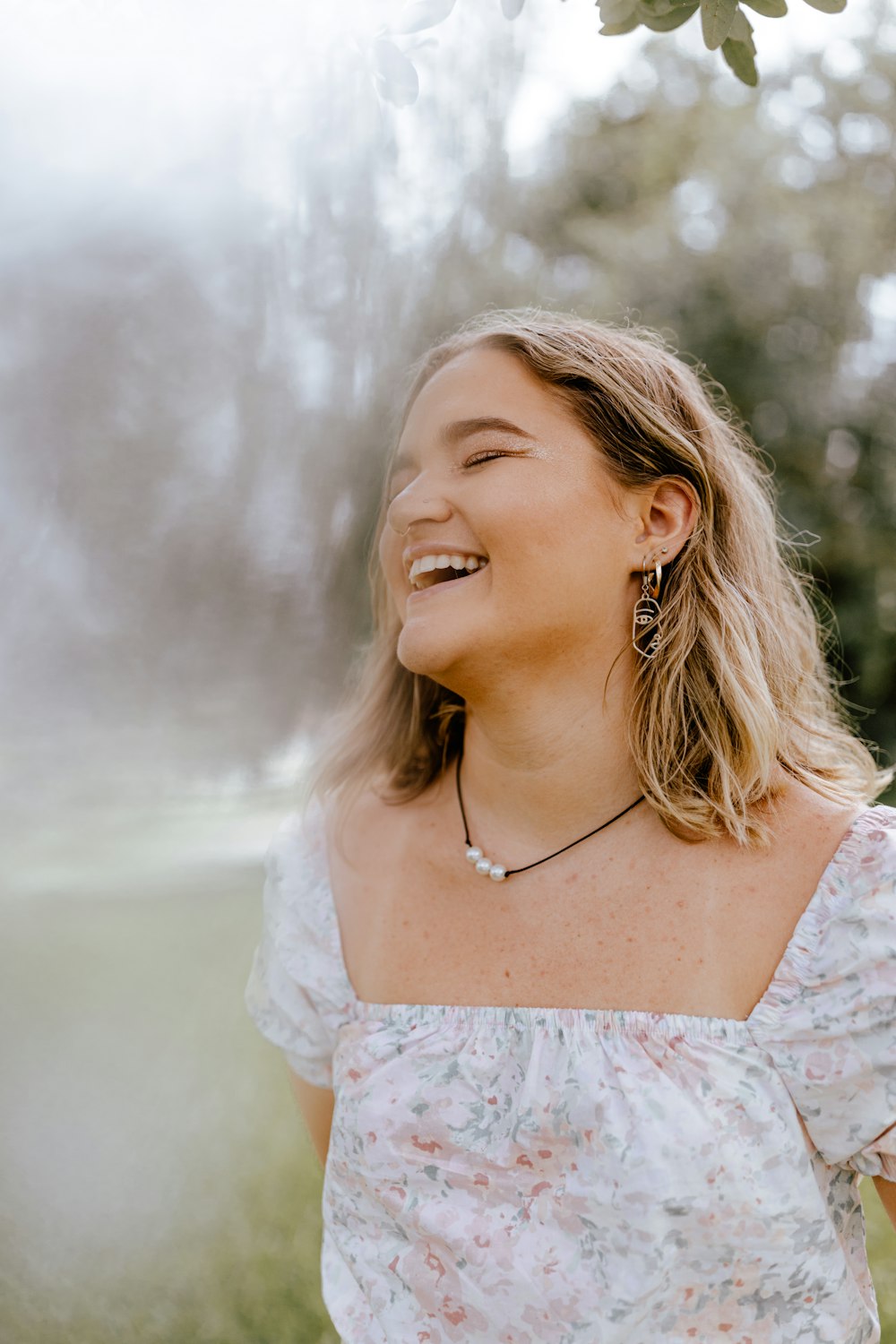 woman in white floral lace dress smiling